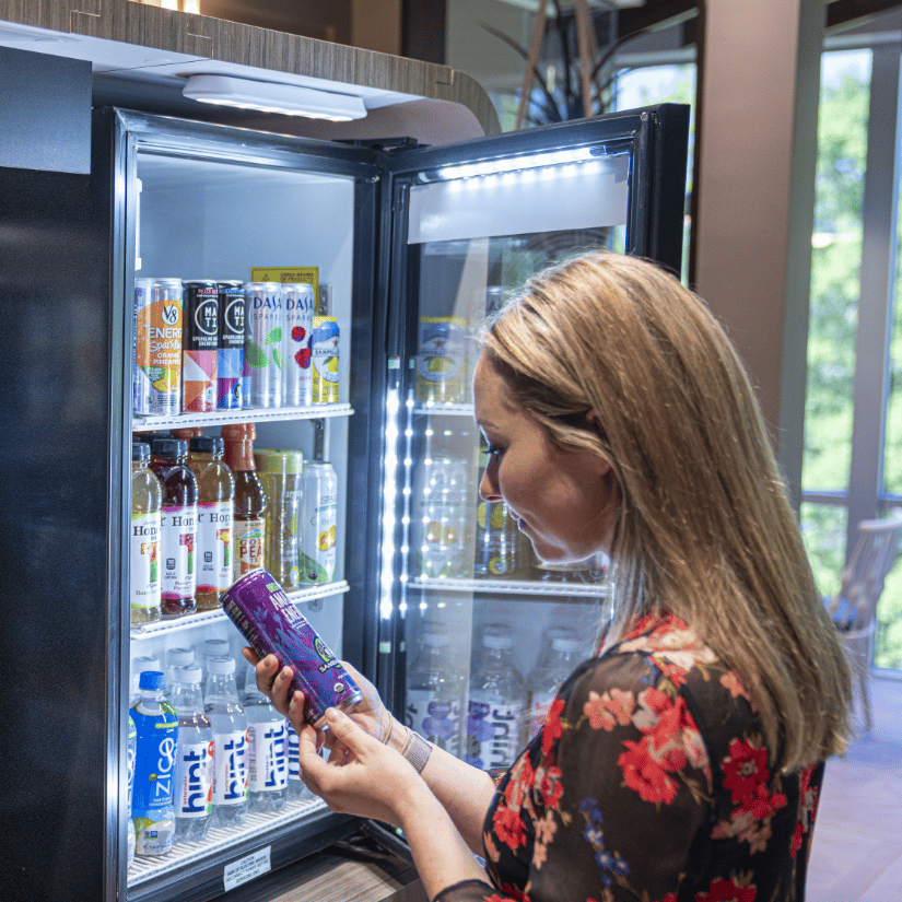 Woman reading a drink label, workplace food service, beverage micro market, Avenue C