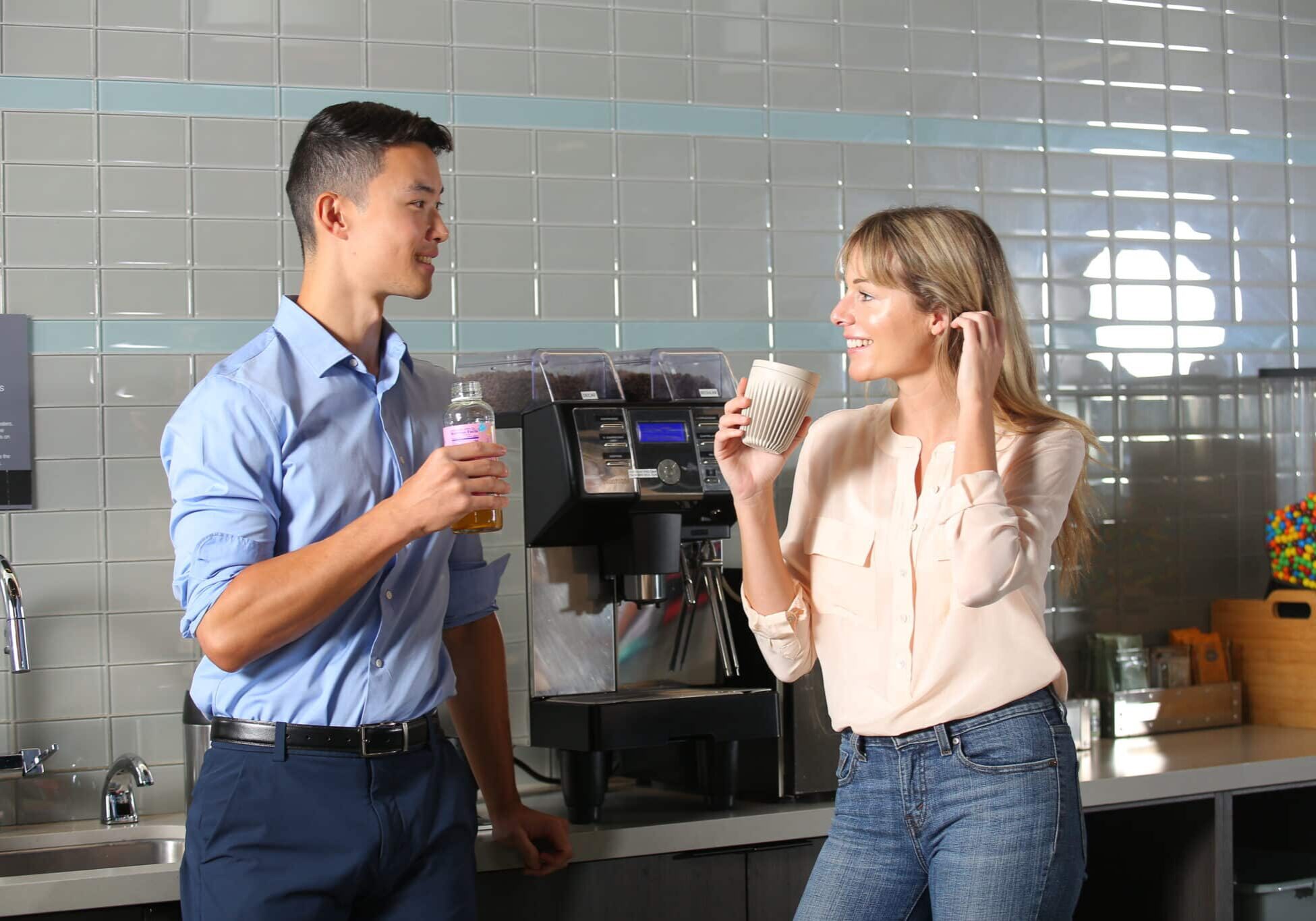 Two people drinking coffee in a ptwmt breakroom